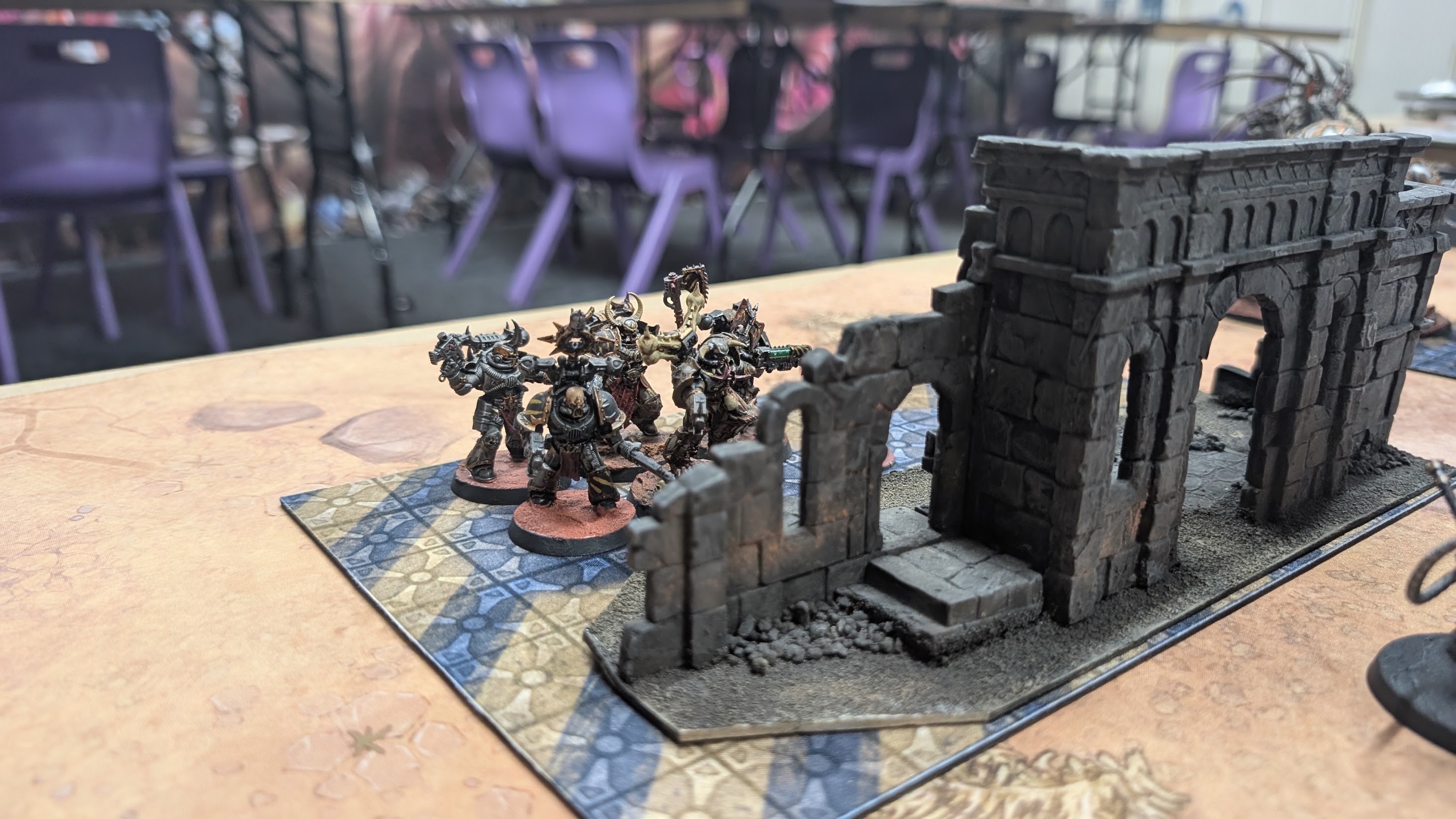 Dark-armoured Iron Warriors Terminators hold a stone ruin on the battlefield