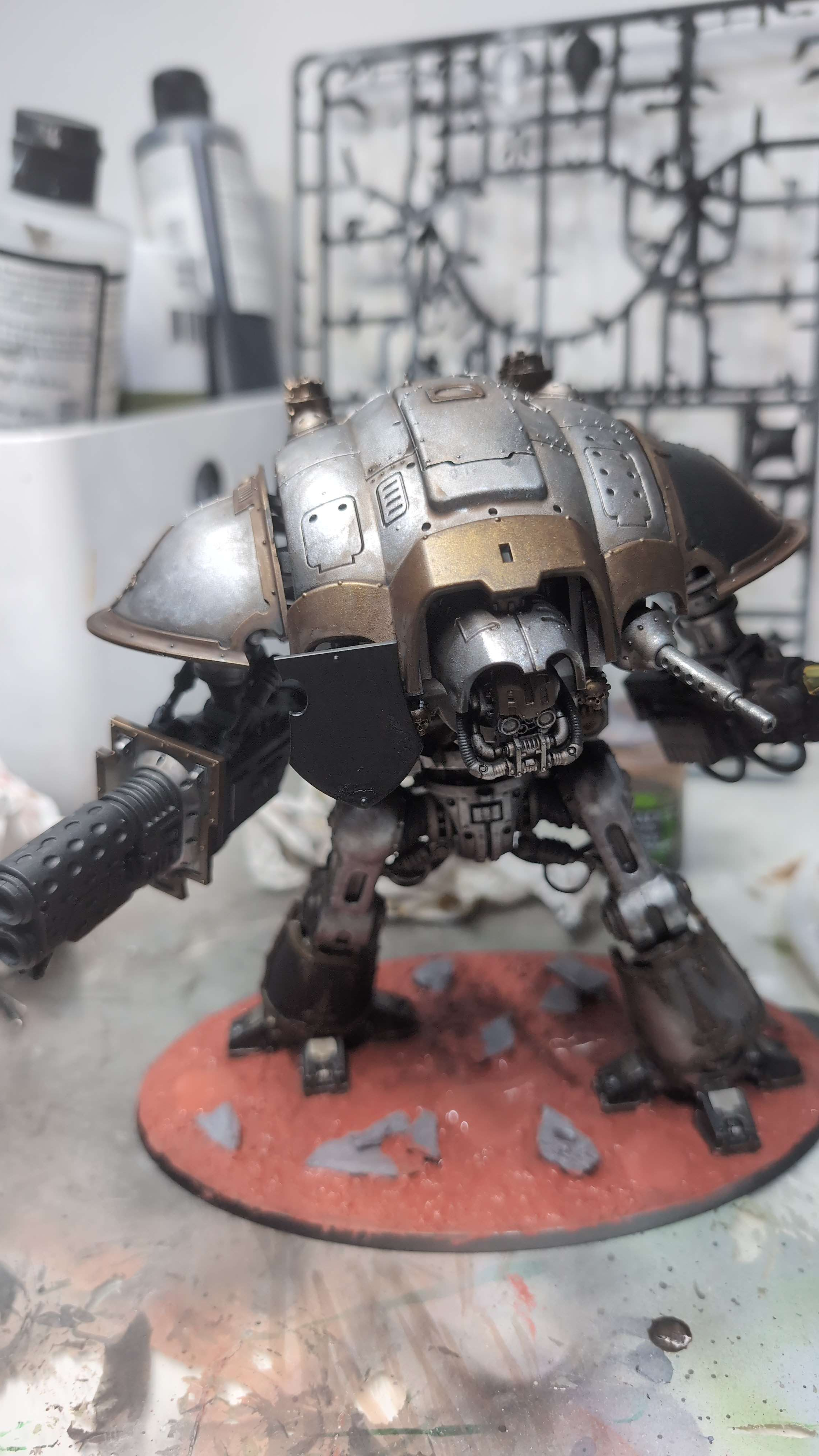 A bare-metal Questoris Knight with twin gatling cannons on a red base