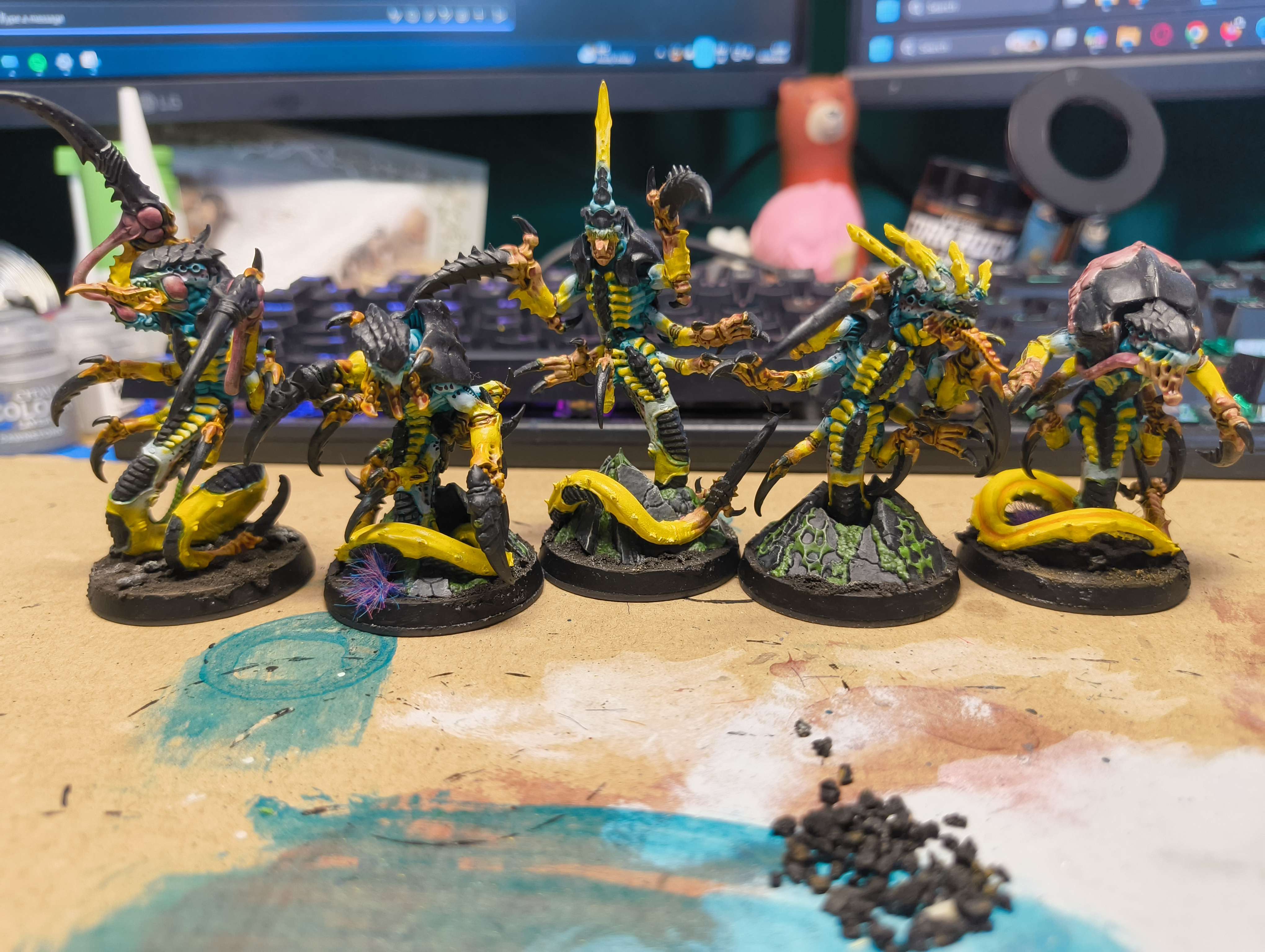 Five teal and yellow Raveners with bright yellow tails on textured bases