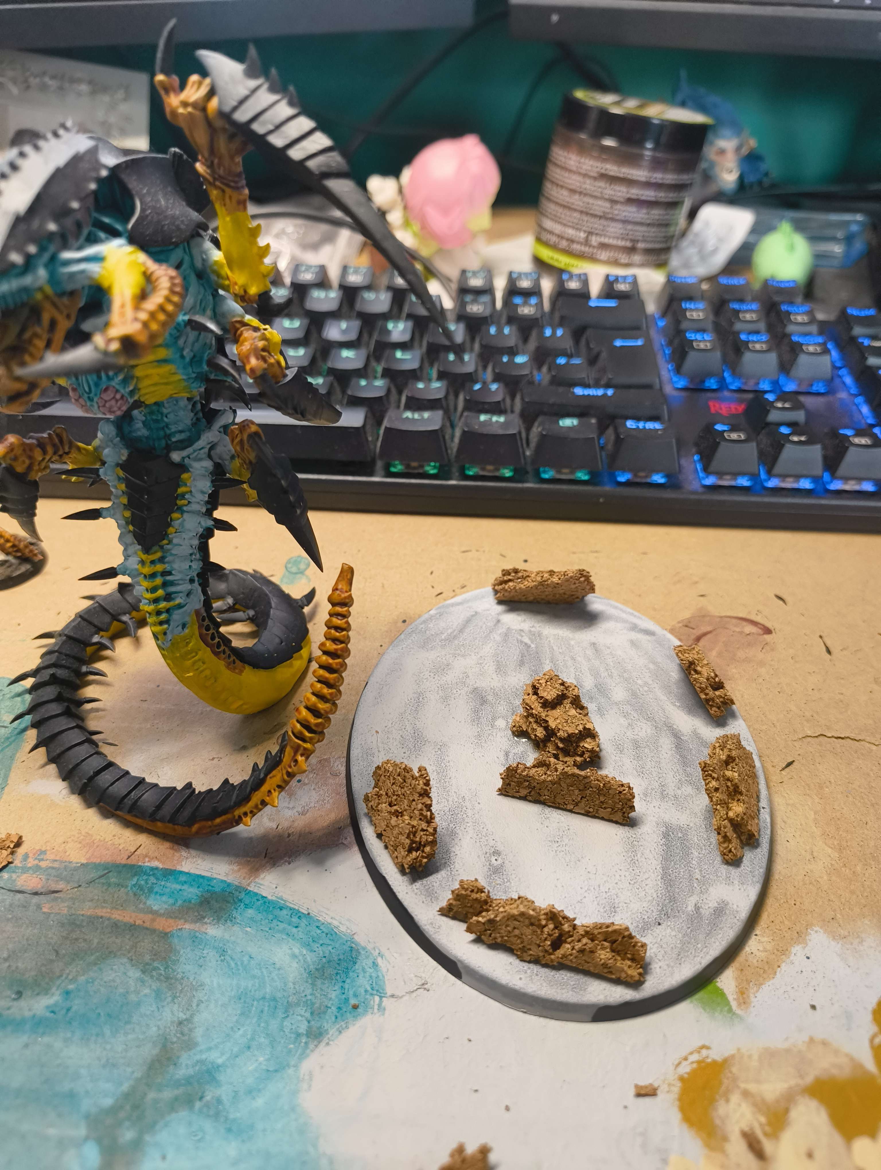 A large oval base with cork rock pieces arranged at angles beside a painted Trygon